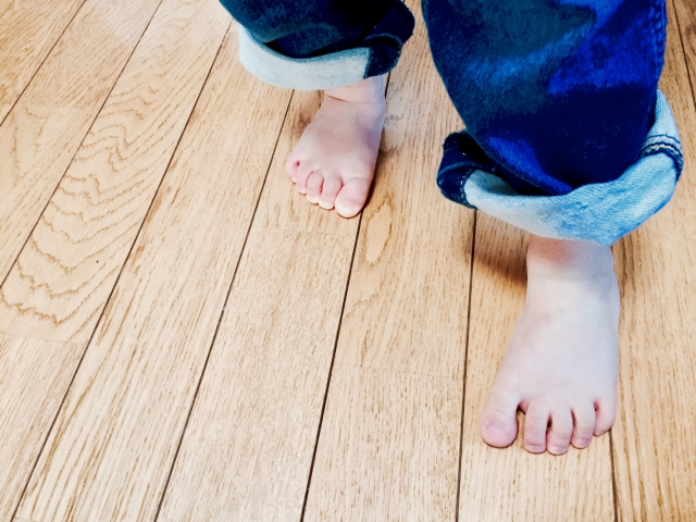 家の床を歩く子供の足